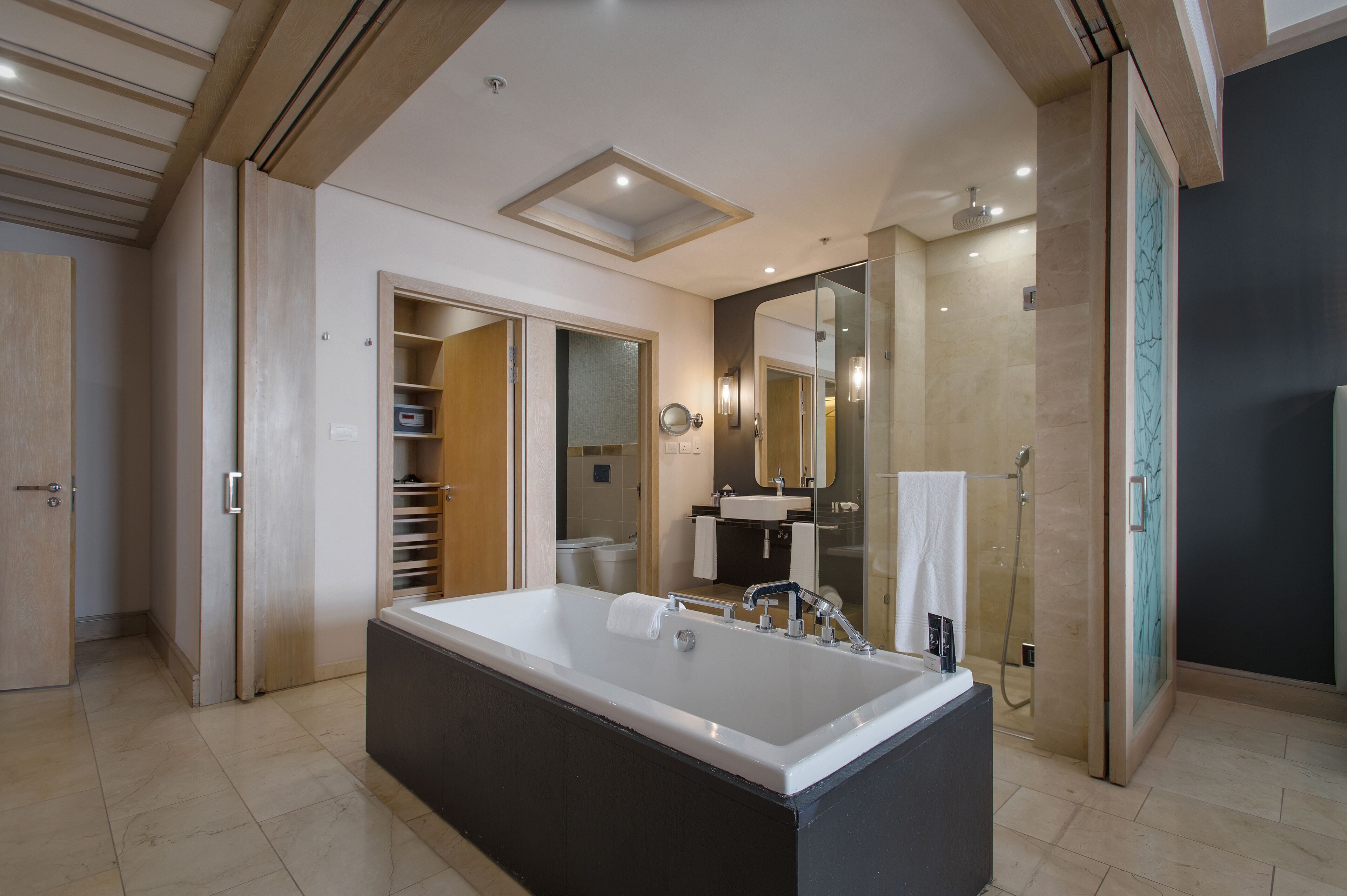 Un bagno moderno con una vasca da bagno ampia, una cabina doccia e un mobile con specchio.