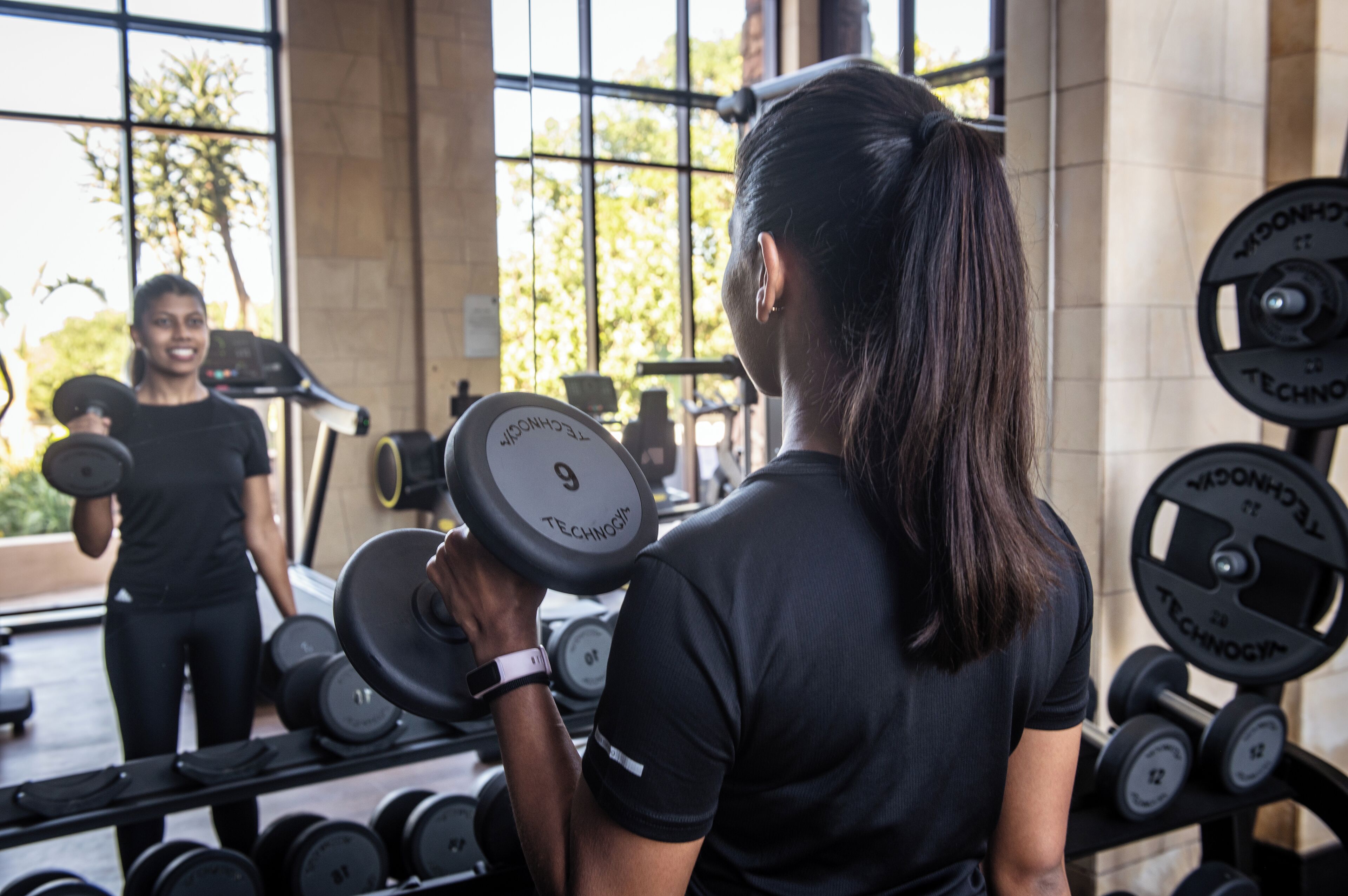 A gym with weightlifting equipment, including dumbbells and barbells.