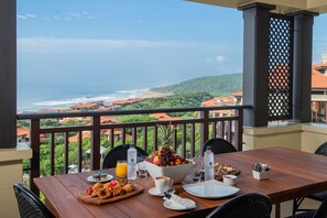 A dining table with breakfast items and a view of the ocean. - The Capital Zimbali (Ballito)