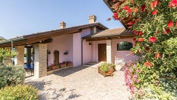 A house with a tiled patio, brick walls, and a wooden pergola.
