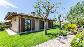 A modern house with a brick exterior, large windows, and a well-maintained lawn.