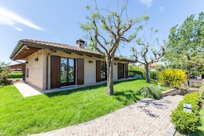 Ein modernes Haus mit Backsteinfassade, großen Fenstern und einem gepflegten Rasen.