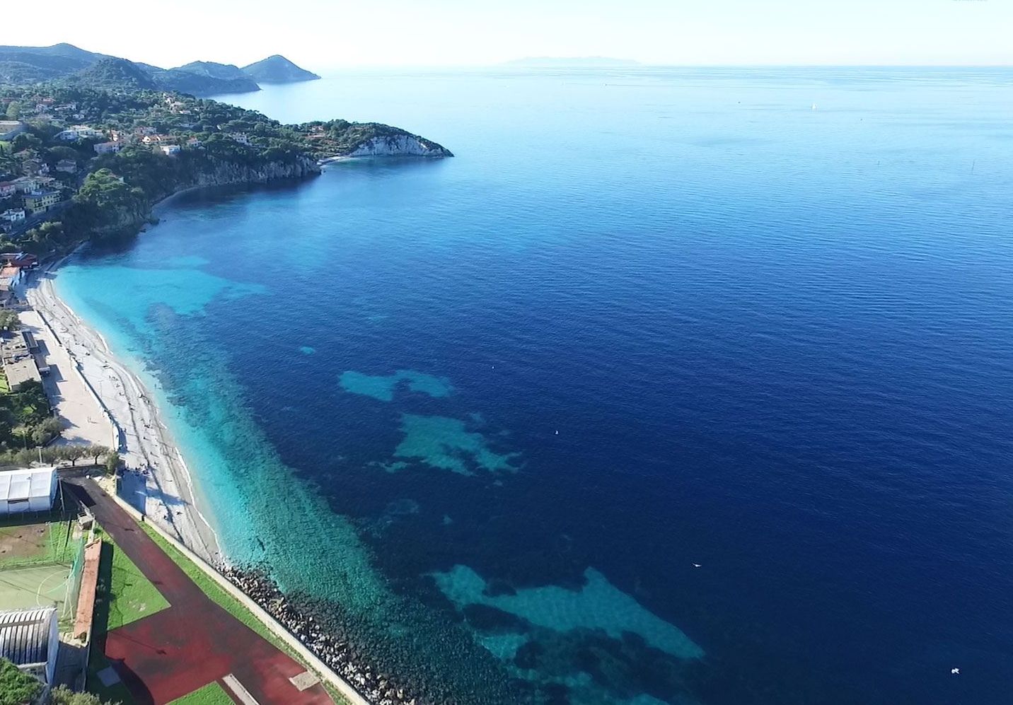 An aerial view of a coastal area with a marked location for Casa Gioia - Le Ghiaie.