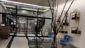A modern interior with a glass table, blue chairs, and decorative branches. - Orbi City Apartment (Batumi)