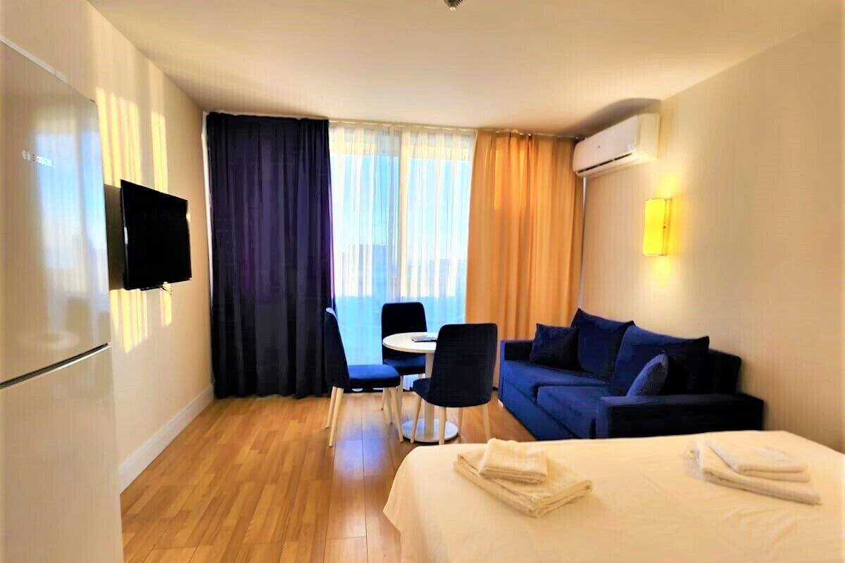 Une chambre d’hôtel équipée d’un lit, d’un bureau, d’une chaise, d’un canapé et d’une télévision.