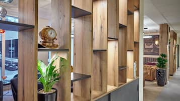 A modern interior with wooden shelving units, a potted plant, and a vintage clock.