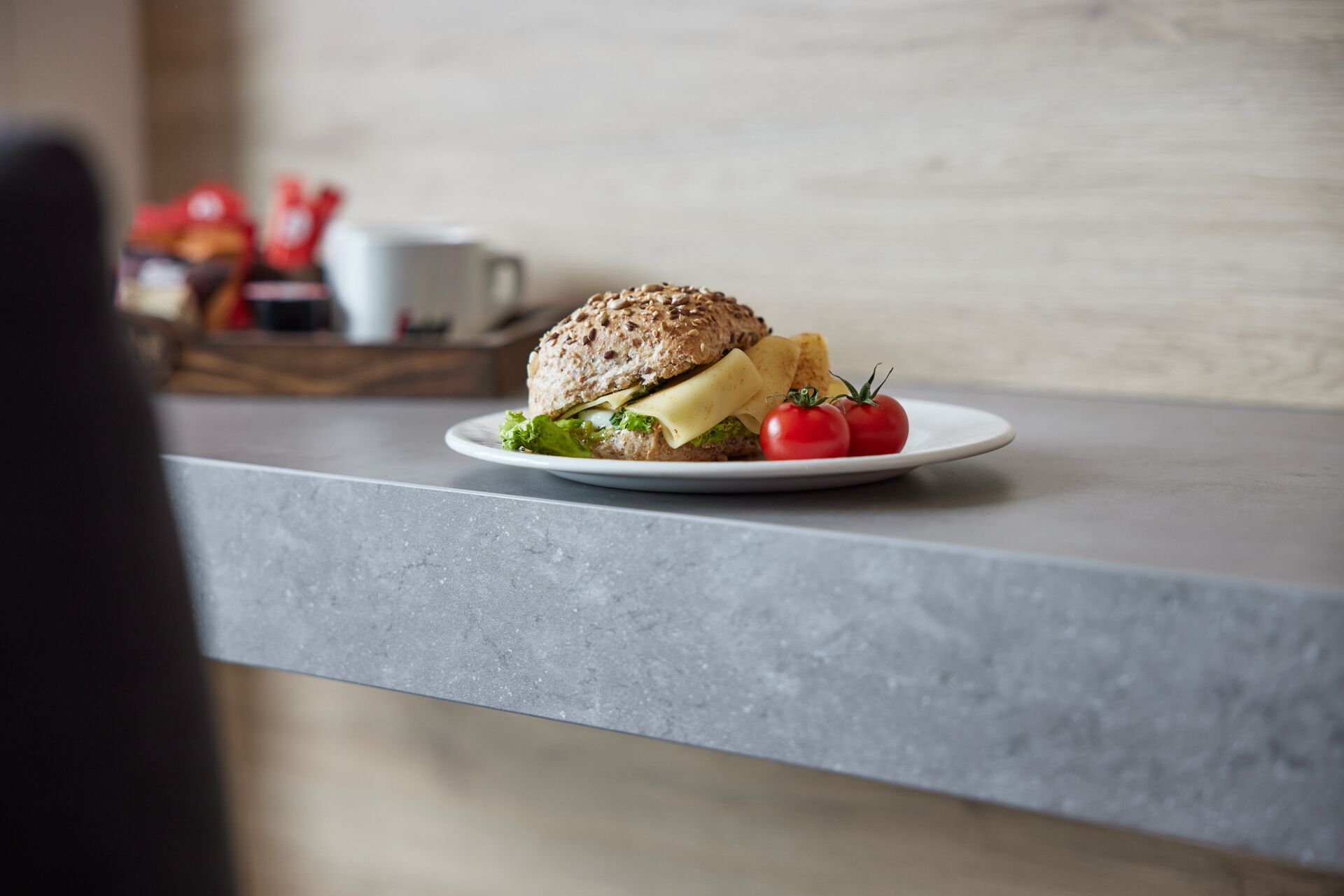 Un sándwich en un plato con tomates y papas fritas sobre una encimera de cocina.