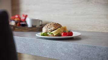 Un sándwich en un plato con tomates y papas fritas sobre una encimera de cocina.