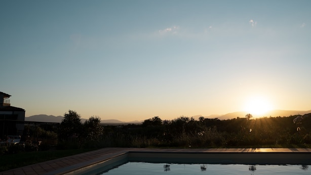 Une piscine avec vue sur les montagnes et sur le coucher de soleil.