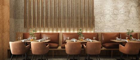 Un restaurante con pared de ladrillo rústico, listones de madera y asientos de cuero.