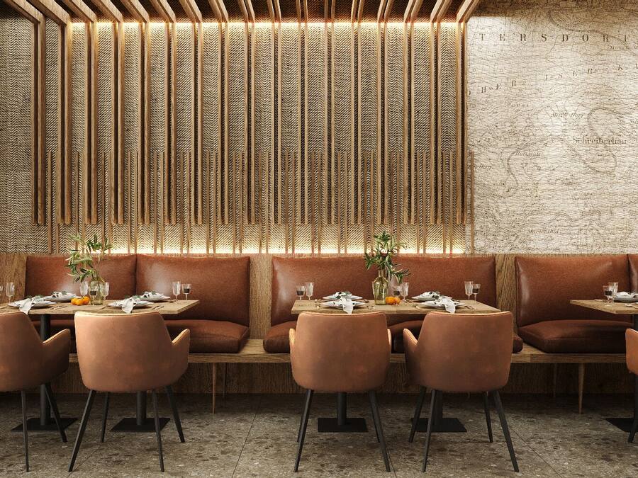 A restaurant with a rustic brick wall, wooden slats, and leather booths.
