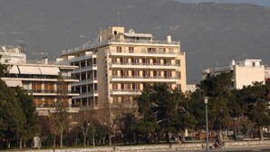 A multi-story building with balconies, surrounded by trees and a mountain in the background. - Park Hotel Volos (Volos)