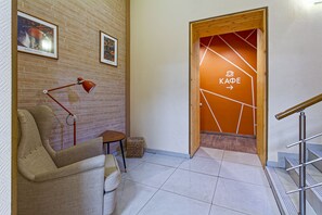 A modern interior with a wooden door marked "KAFFE" and a red lamp on a brick wall. - Minima Krasnye vorota (Moscow)