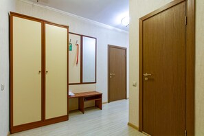 A room with a wooden wardrobe, a bench, and a door. - Minima Krasnye vorota (Moscow)
