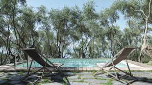 Two lounge chairs facing a swimming pool surrounded by trees. - Cà del Mago, luxury, private heated pool and spa a stone's throw from the sea (Lerici)