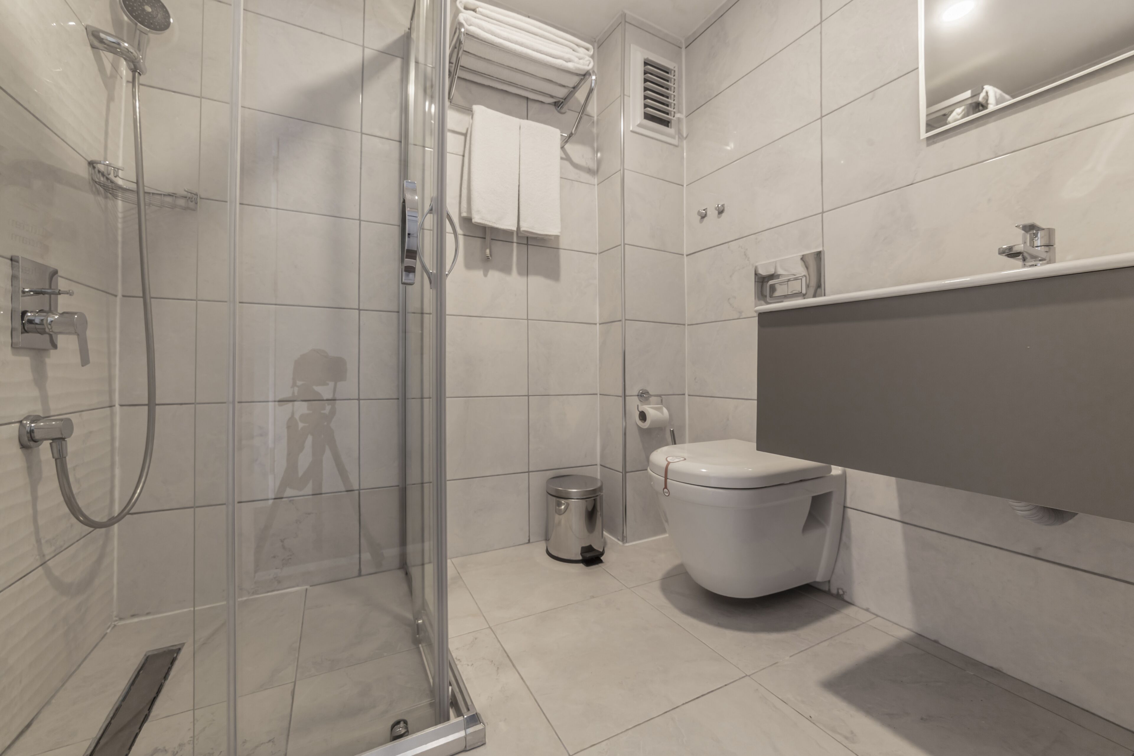 rainfall showerhead, hair dryer, slippers, towels