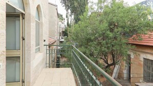 A narrow pathway with a metal railing, flanked by buildings with stone facades and tiled roofs. - Keren Kayemet - Four Bedroom Apartment, Sleeps 8 (Jerusalem)