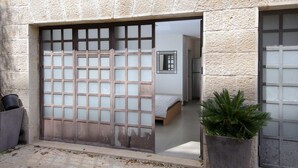 Une pièce de style japonais traditionnel, avec un sol recouvert de tatamis, un lit bas en bois et une porte coulissante dotée de panneaux en verre dépoli.