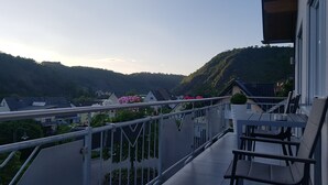 A balcony with a view of a valley and houses. - Ferienhaus Moselcharme "moselblick" (Alken)