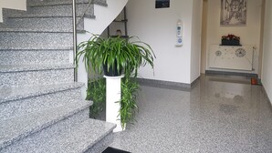 A modern interior with a granite staircase, a potted plant, a water dispenser, and a framed artwork on the wall. - Ferienhaus Moselcharme "moselblick" (Alken)