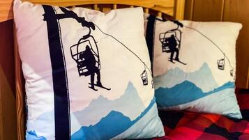Een bed met een geruit sprei en twee kussens met een ontwerp van een skilift.