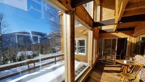 Une terrasse en bois offrant une vue sur un paysage enneigé.