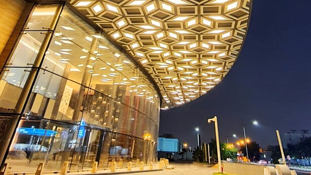 A modern building with a distinctive geometric ceiling design and large glass windows. - The Bentley Luxury Hotel and Suites (Doha)