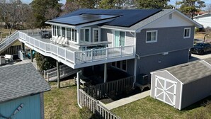 Une maison à deux étages dotée d’un patio couvert et de panneaux solaires sur le toit.