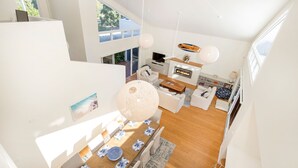 Een moderne, open woonruimte met een eethoek, keuken en zithoek.