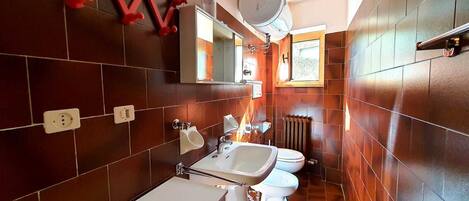 Et moderne badeværelse med håndvask, toilet og spejl.