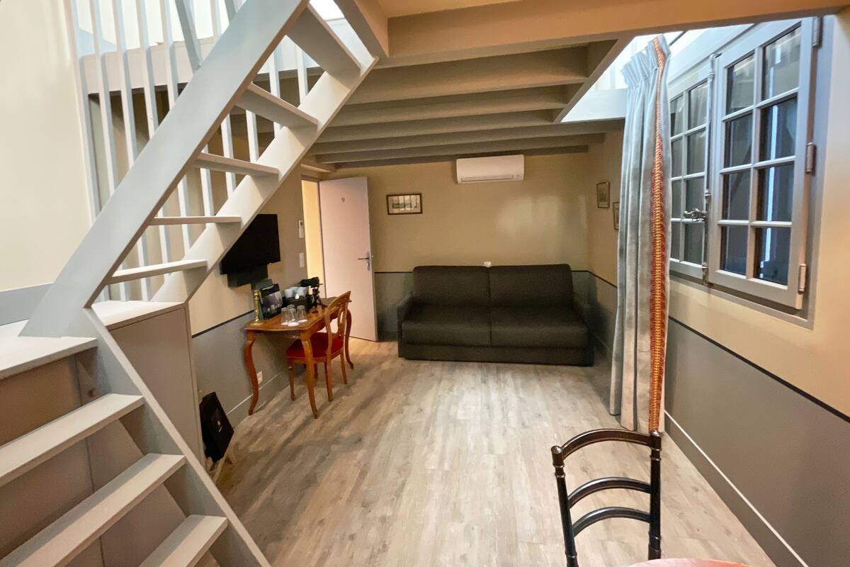 A staircase leading to a landing with a sofa and a table.