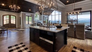 A spacious kitchen with a large island, dark wood cabinetry, and a view of the outdoors.