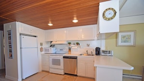 A compact kitchen with white cabinetry, a microwave, a stove, a dishwasher, and a small countertop with a toaster. - Beachmark 3D-Oceanfront 73rd St, Free WiFi, Pool, Elev, W/D, AC (Ocean City)