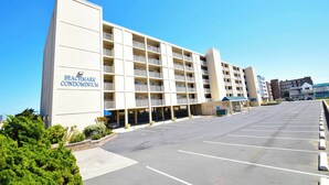 A beachfront condominium building with a parking lot in front. - Beachmark 3D-Oceanfront 73rd St, Free WiFi, Pool, Elev, W/D, AC (Ocean City)