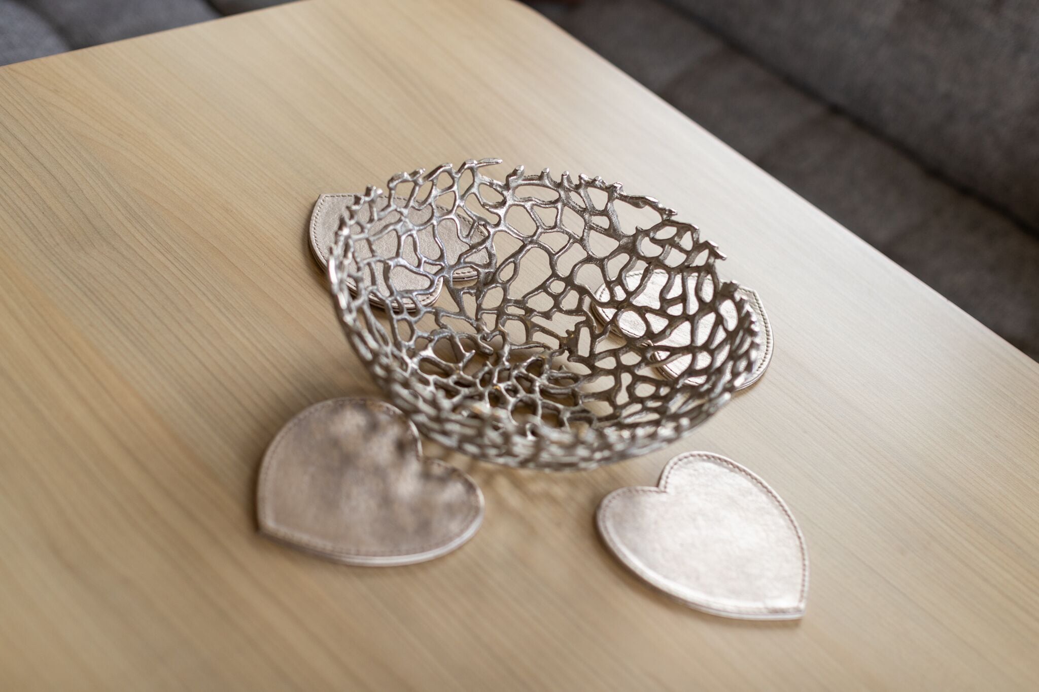 A metallic spherical object with a lattice design on a wooden surface.