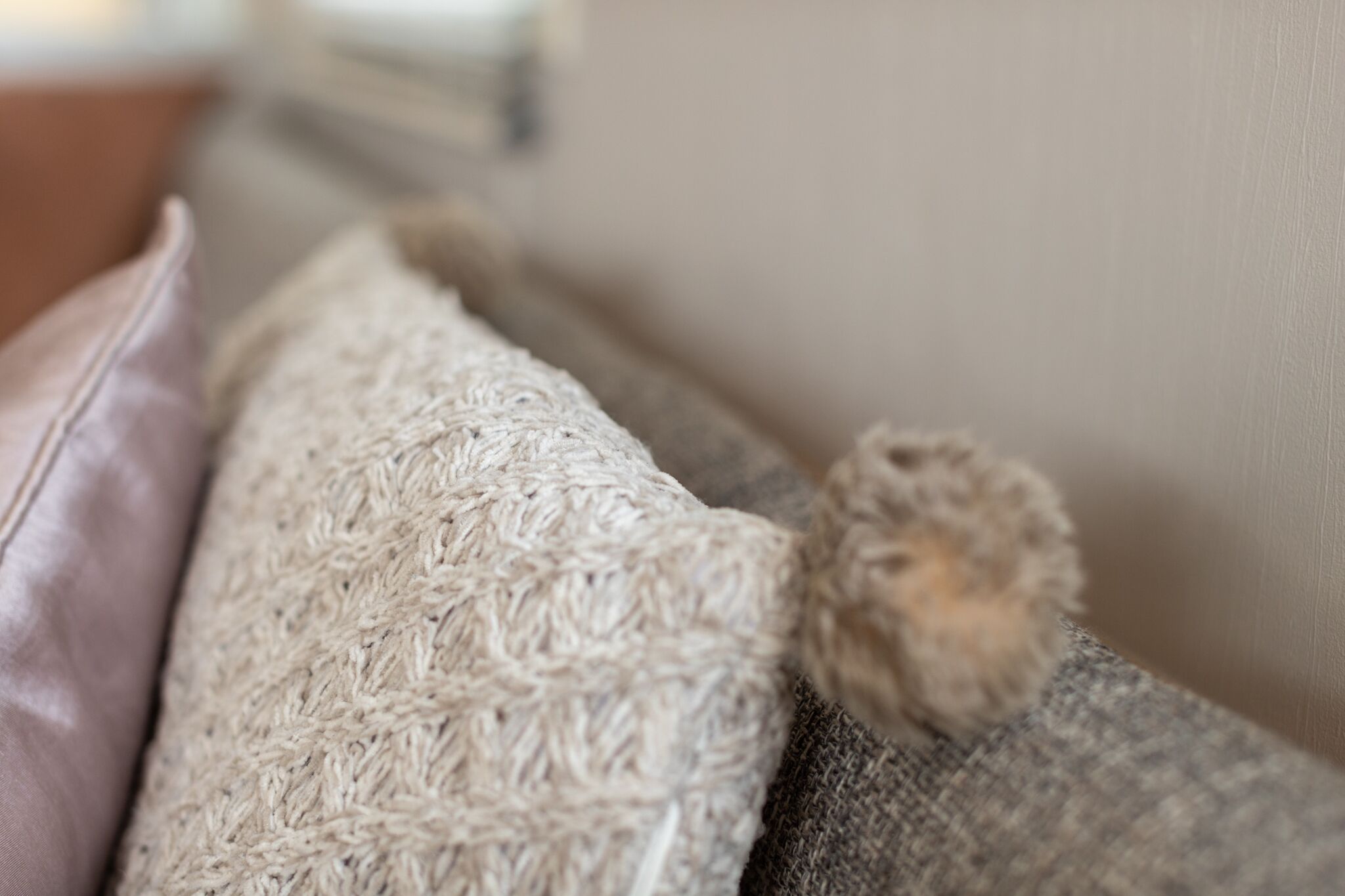 A close-up of a textured fabric, possibly a throw, on a piece of furniture.