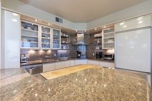 Una cocina moderna con encimeras de granito, armarios empotrados y una isla central.