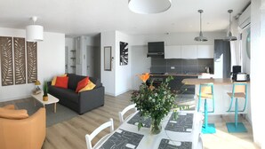 A modern apartment with a living room, dining area, and kitchen. - LE Logis DES Jalles (Saint-Médard-en-Jalles)