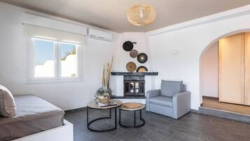 Una sala de estar moderna con chimenea, un sofá, una mesa de centro y una lámpara colgante.