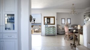 A spacious room with a dining area, a dresser, and a view of the sea. - EXECUTIVE VILLA WITH PRIVATE SWIMMING POOL (PAROS)