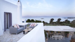 A modern outdoor seating area with a view of the sea and distant mountains. - EXECUTIVE VILLA WITH PRIVATE SWIMMING POOL (PAROS)