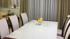 A dining area with a table, chairs, and a bowl of fruit. - Уютная квартира в Батуми с джакузи. (Batumi)