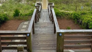 Una passerella di legno che conduce a una spiaggia con una bandiera americana.