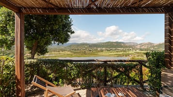 A wooden pergola with a view of a lake and mountains.