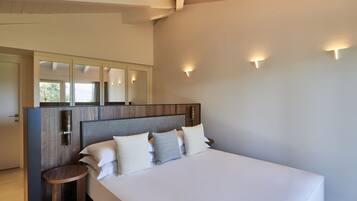 Una habitación de hotel moderna con una cama grande, un cabecero de madera y una pequeña mesa redonda.