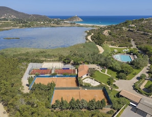 Een landhuis aan de kust met een tennisbaan, zwembad en uitzicht op zee.