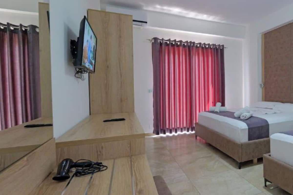 Habitación triple, vista al jardín | Escritorio, tabla de planchar con plancha, wifi gratis y ropa de cama