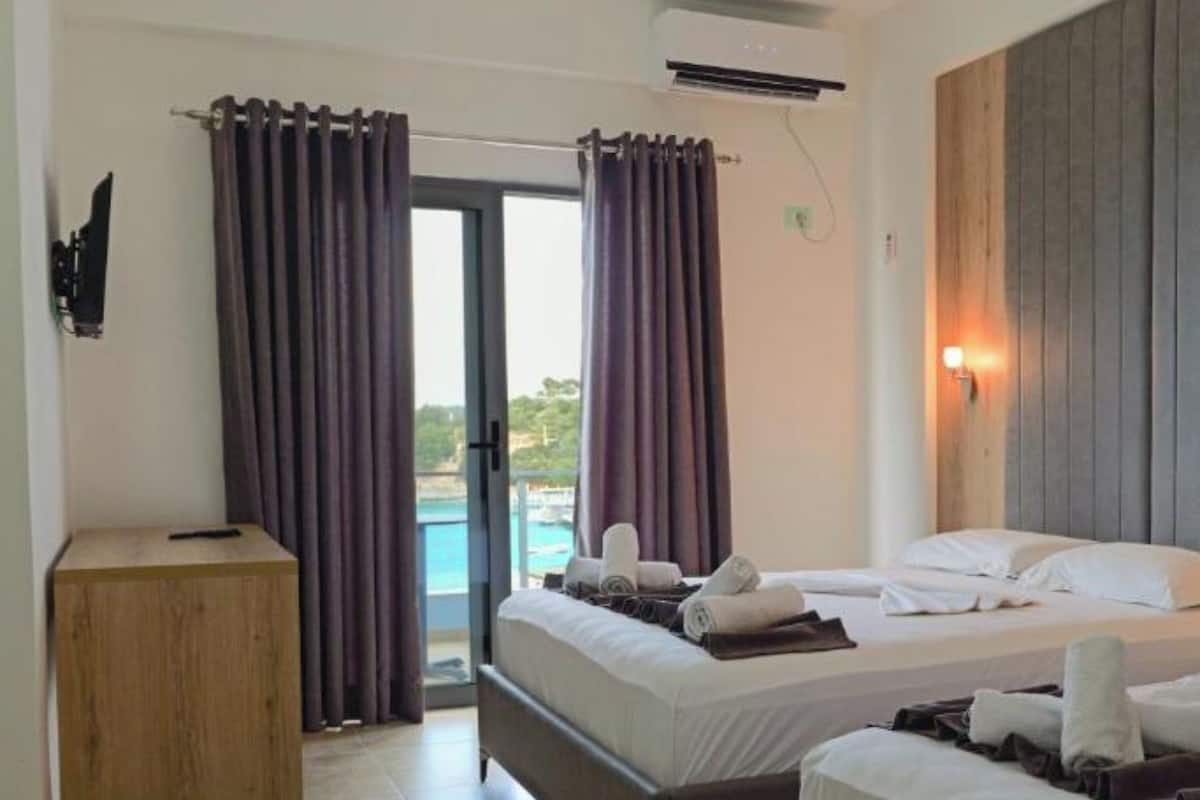 Habitación triple, vista al mar | Escritorio, tabla de planchar con plancha, wifi gratis y ropa de cama