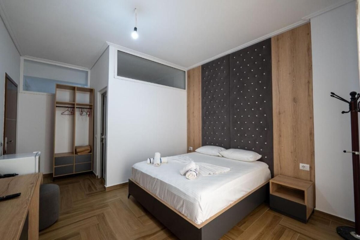 A modern bedroom with a bed, bedside table, and a built-in wardrobe.