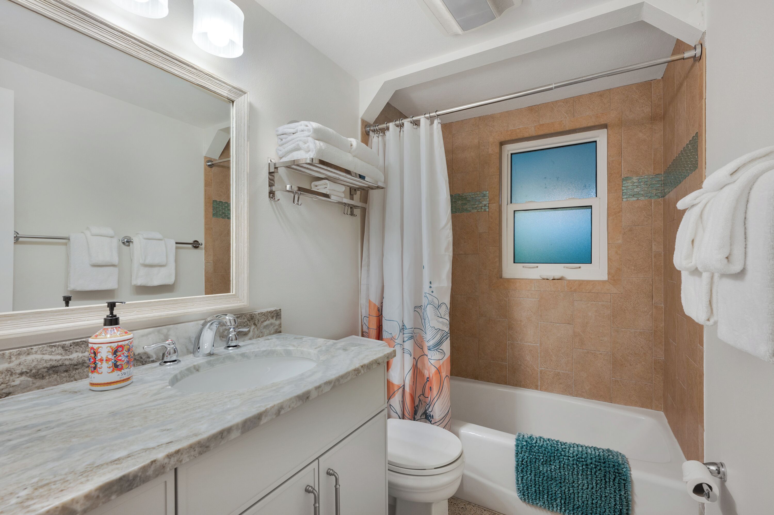 Un bagno con lavandino in marmo, un water, una vasca e una tenda da doccia.